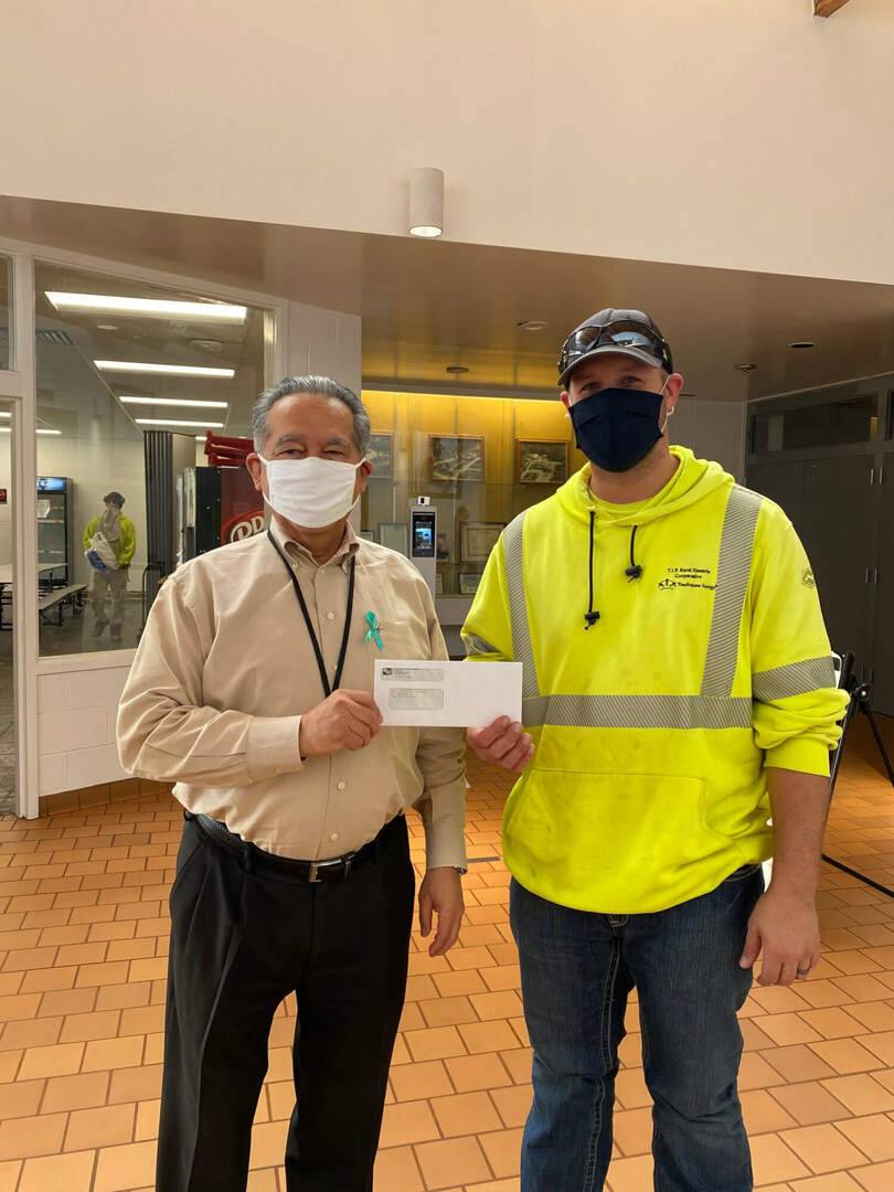 Two men holding the donation from T.I.P. Rural Electric Cooperative