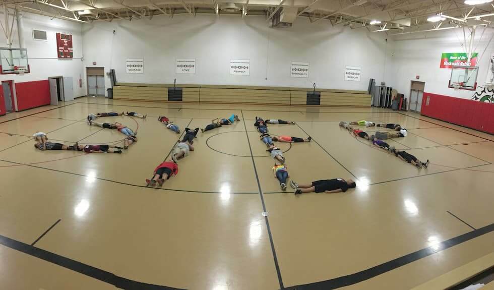 Kids laying on the ground spelling out "SYEP" with their bodies